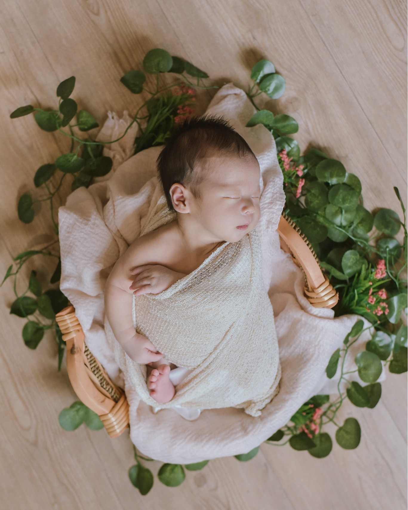 Newborn in basket with flowers